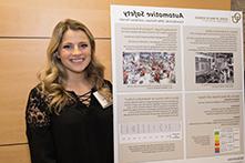 image of Ciara Bazinski standing next to her research poster